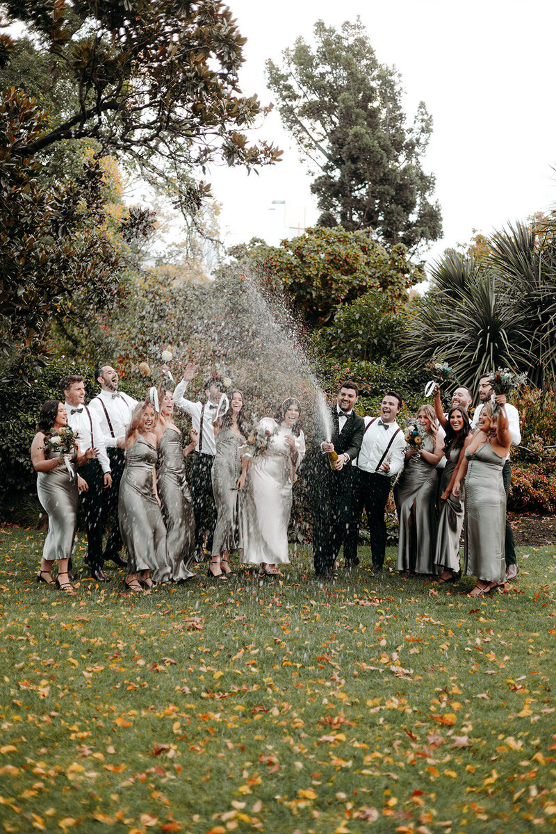 Skylar and Aaron spraying champagne after their wedding