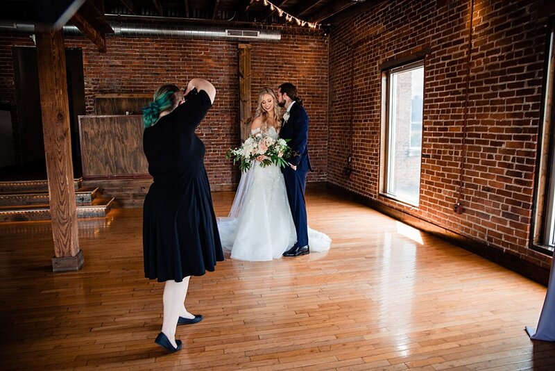 Behind the scenes photo of Mahlia working with newlyweds during their wedding portraits