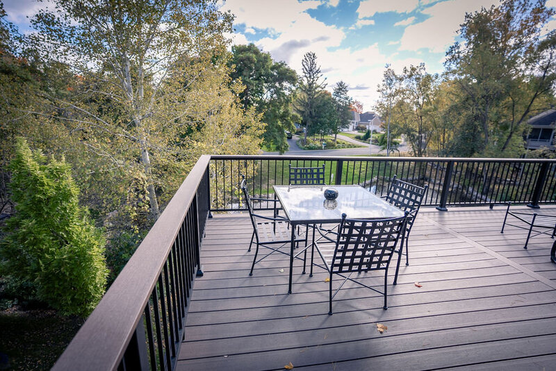 Low-maintenance deck with matching drink rail on top of aluminum picket railing. 