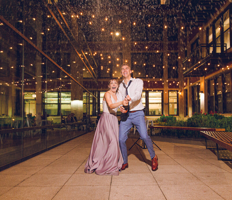 A couple pops champagne at their wedding at Greenhouse Loft in Chicago