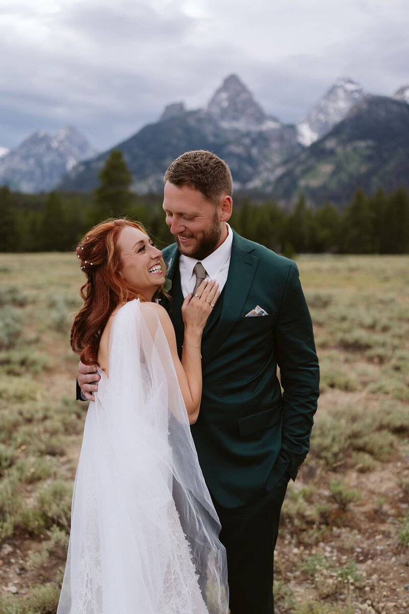A couple looking into each others eyes laughing in the Sawtooth mountains in Stanley, Idaho
