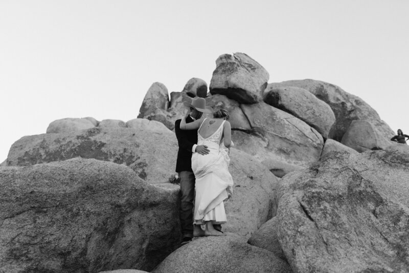 black and white image bride and groom on rocks