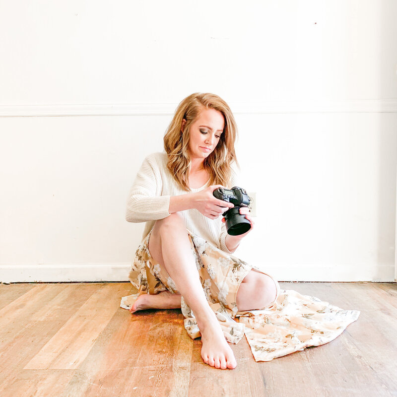 birmingham photographer holding her camera sitting on the floor