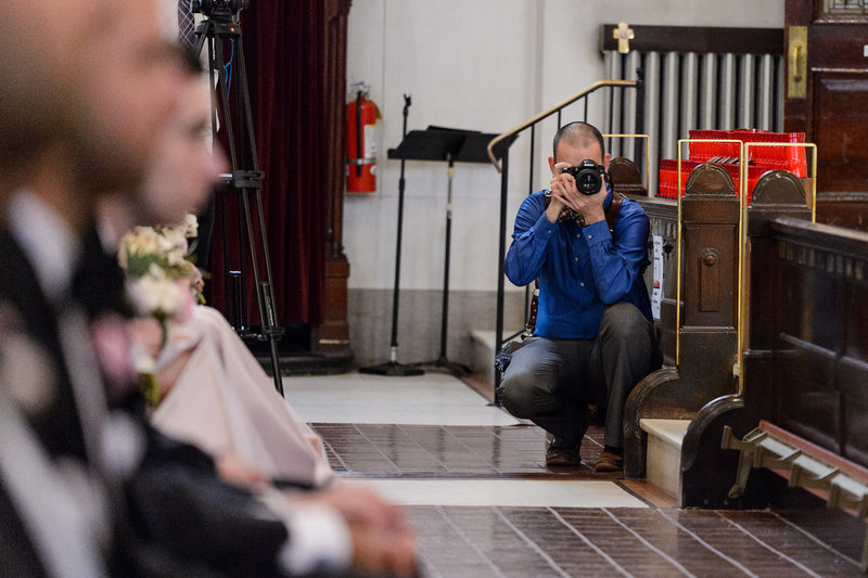 Russ Hickman working in a church and photographing a ceremony.