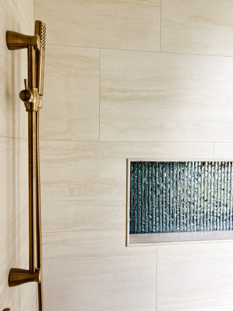 Winter springs bathroom remodel featuring beige tiles and blue glass feature tile.  Gold shower trim brings out the warmth from the beige tile.