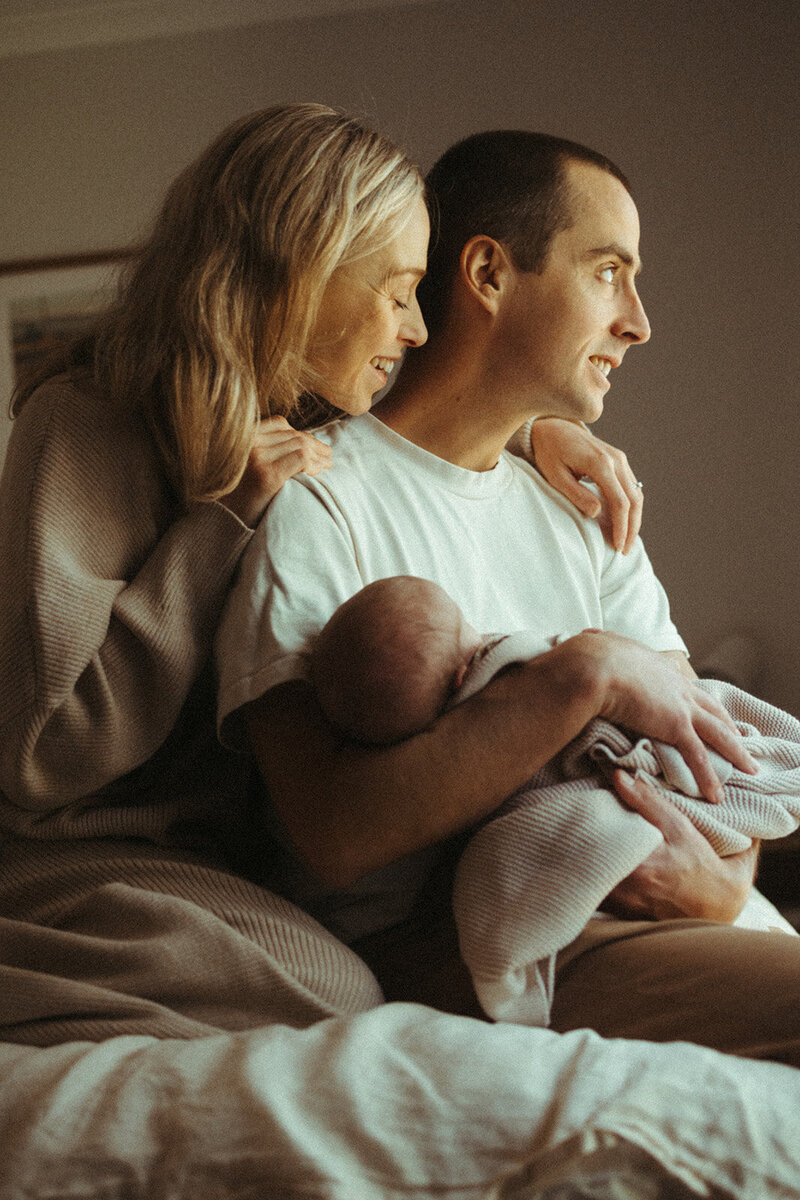 Newborn baby held in parents arms