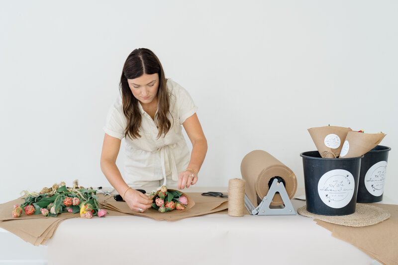 florist arranging tulips in brown paper for branding photos