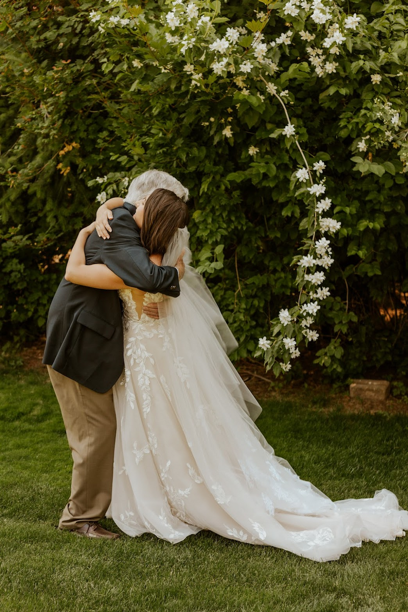 Trisha and her grandpa hugging on her wedding day, while she wears a veil made with lace from her Grandma's wedding gown.