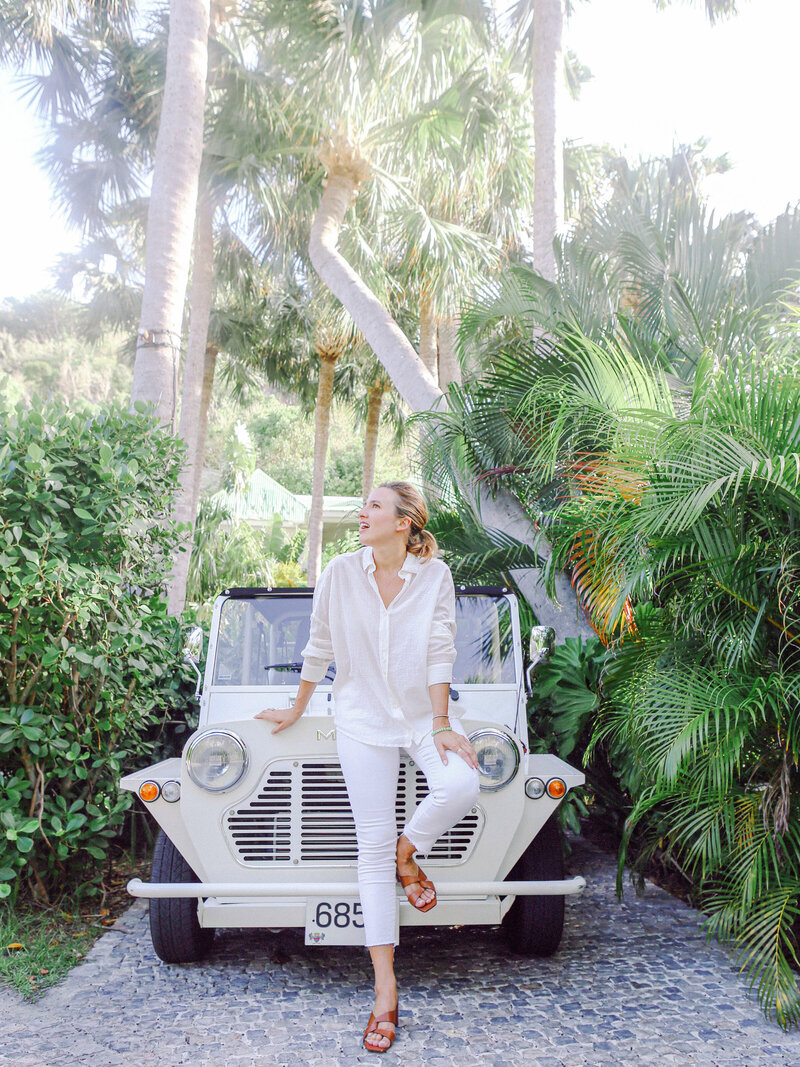 Photographer Tisa Sencur leaning on car surrounded by palm trees