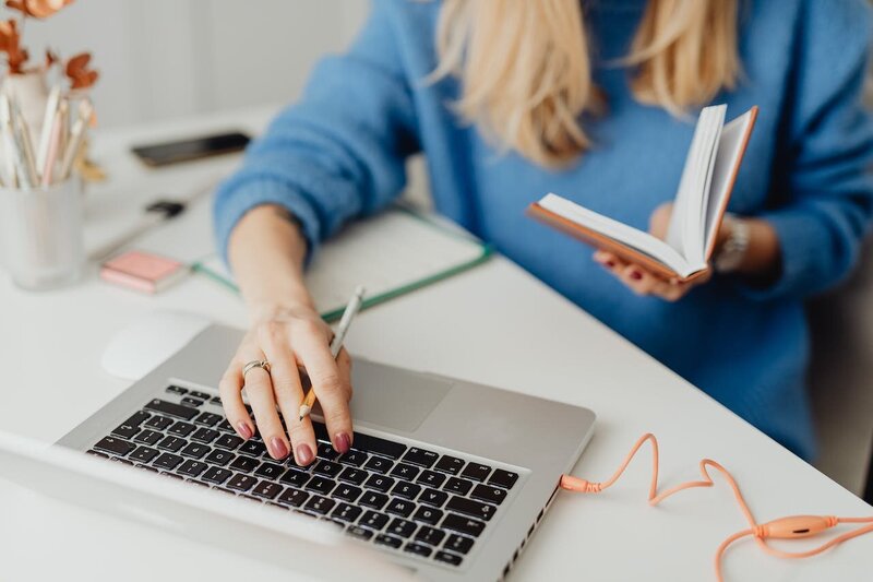 woman on a laptop with a pen in her hand