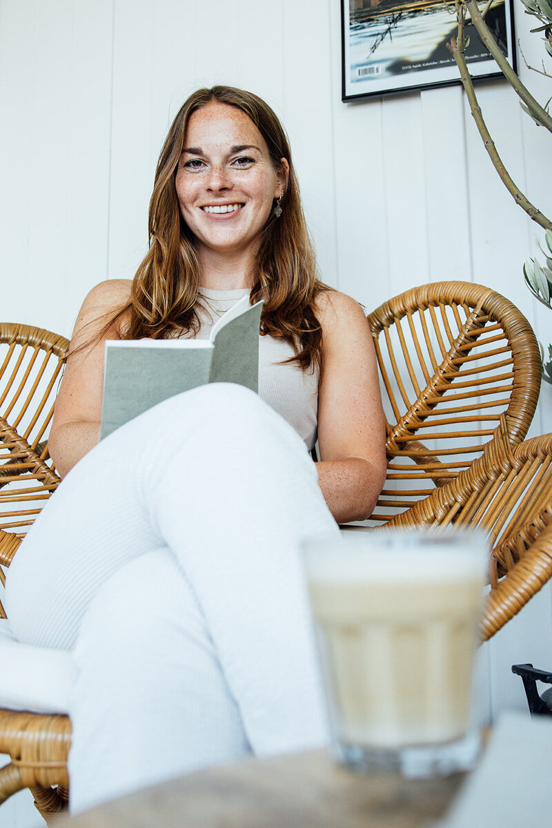 Eva, tekstschrijver en schrijfcoach, met schrift en koffie verkeerd.