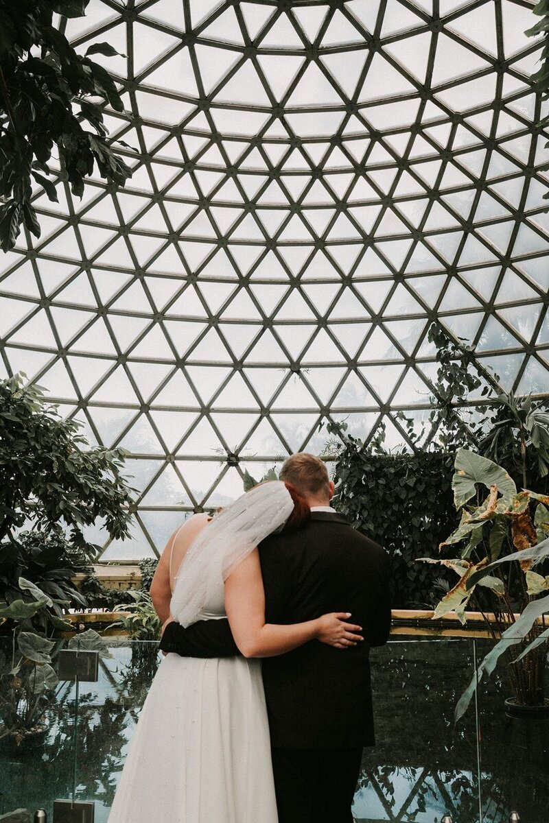 A bride and a groom hugging next to a pond in Queensland