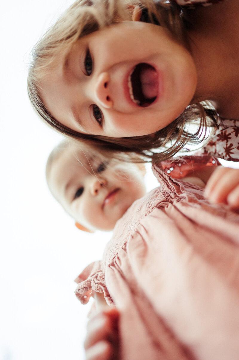 Two toddlers looking down into the camera.