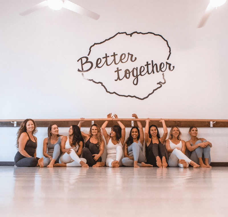 Group of women sitting under better together wall at Barre Soul Kauai studio