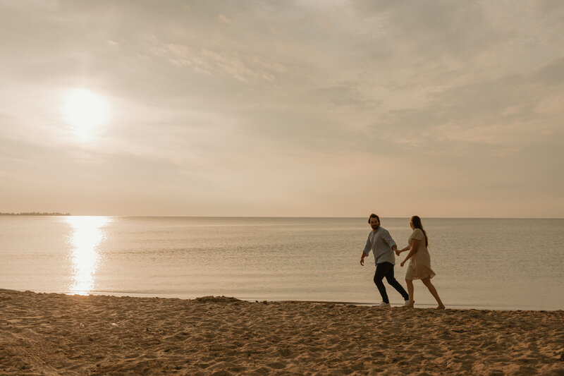 photo of couple running on beach