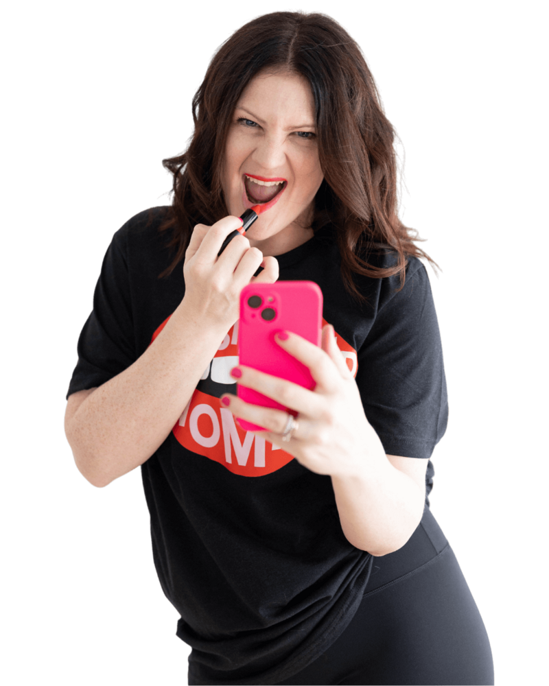 Emily putting on red lipstick while holding a pink iphone.