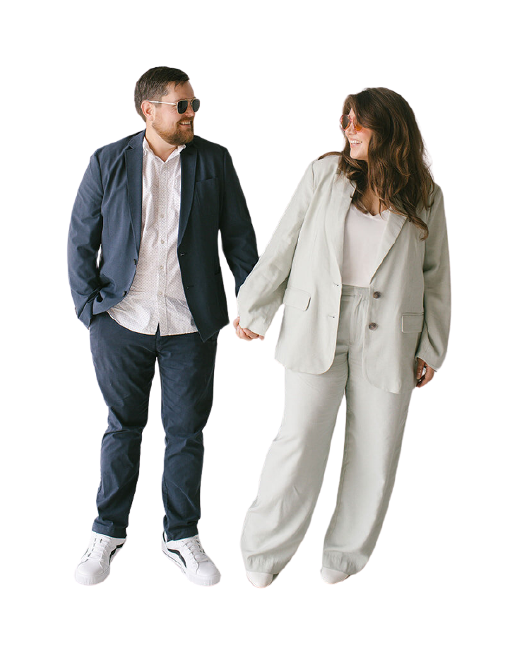 A man and woman dressed in suits stand together, showcasing a polished and sophisticated appearance.