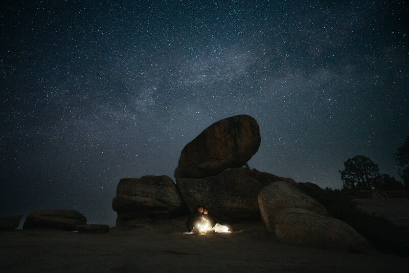 Hiking wedding stargazing, couple lays on a blanket with the milky way above them