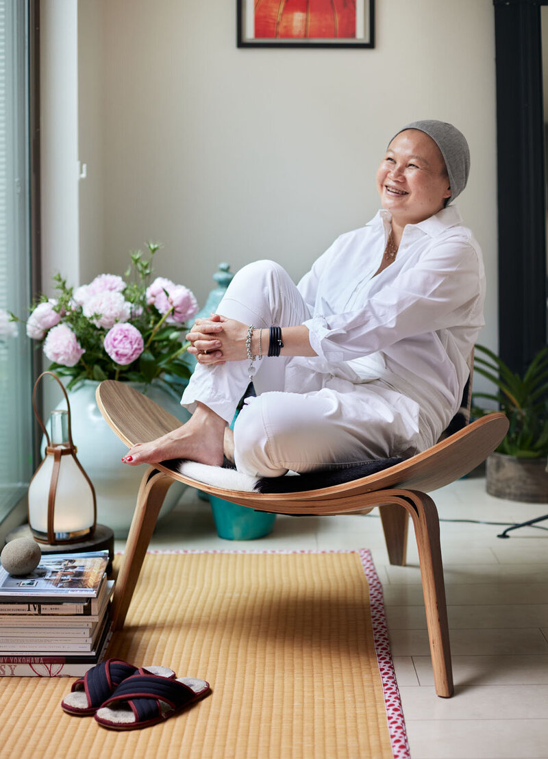 Thara, an interior designer, sitting in an armchair and smiling