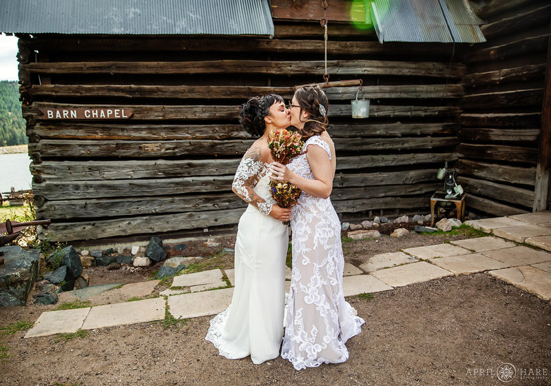 Brides kiss during first look at The Barn at Evergreen Memorial Park