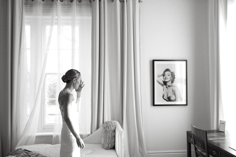 Bride wipes a tear as she takes a moment to gather her thoughts in the Marilyn Monroe suite in The Cape, a Prince Edward County wedding venue. Images are thoughtfully captured by PEC wedding photographer Jennifer van Son