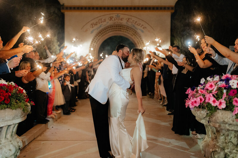 Bride and groom dancing down an aisle during their sparkler exit