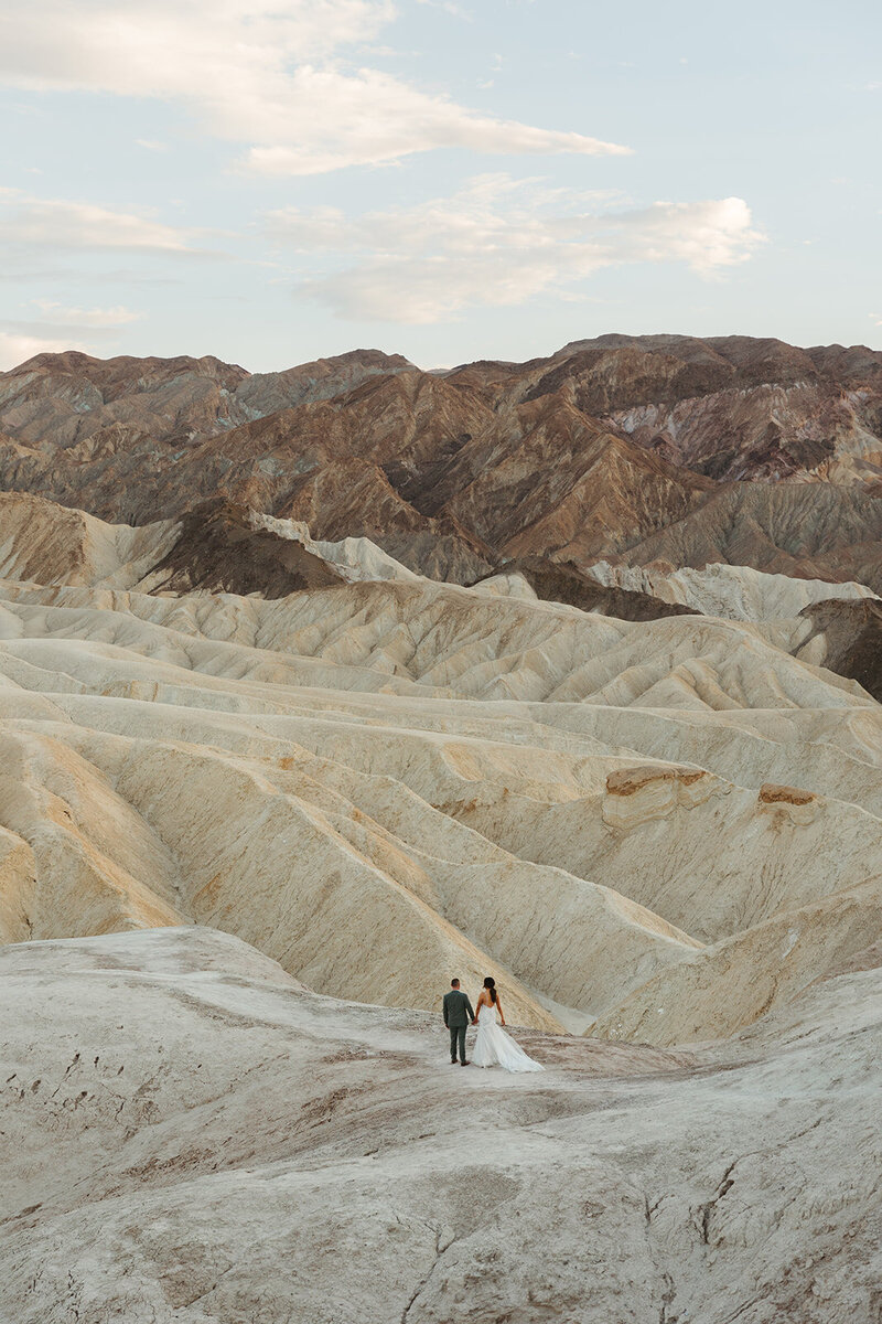couple walking through the desert at sunset
