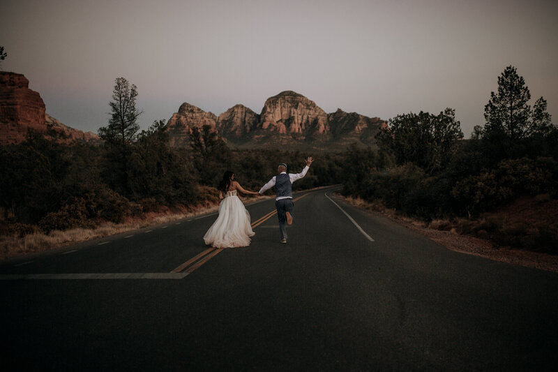 bride and groom running around sedona after their wedding