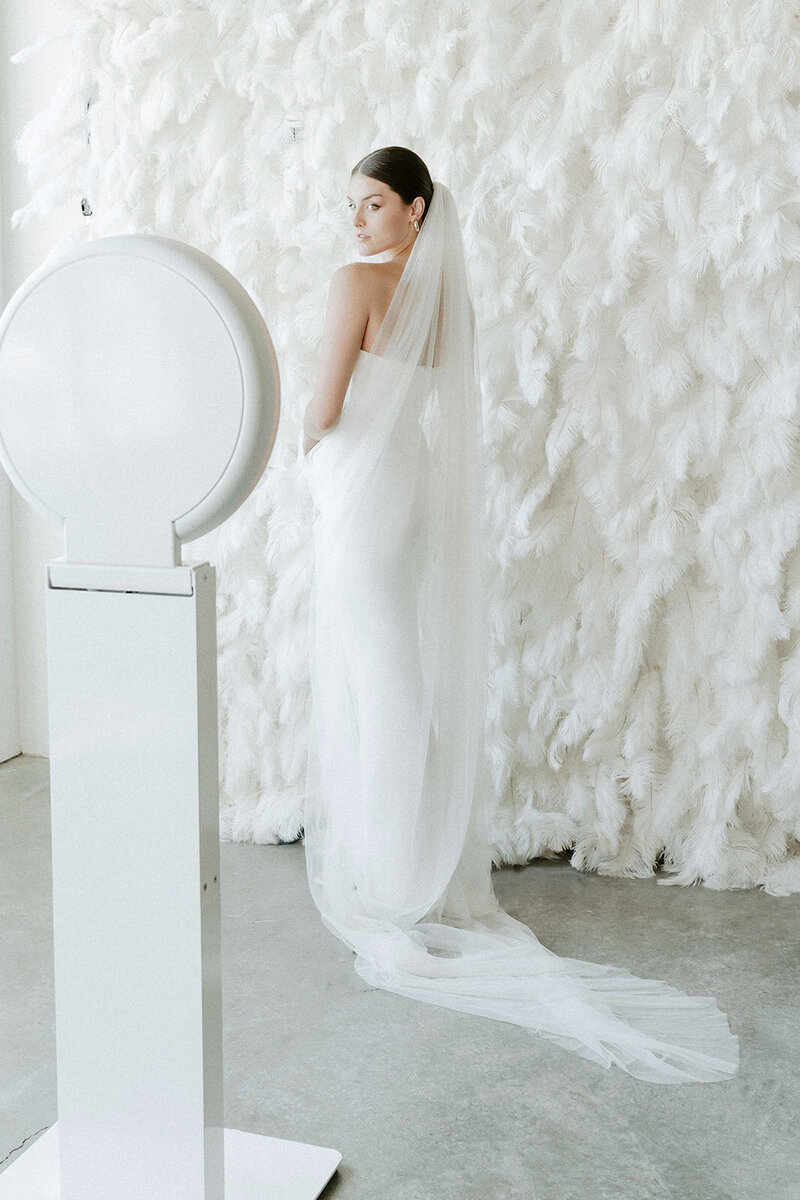 Digital photo booth for weddings in Ottawa, Montreal, and Toronto. Picture also includes a bride and a floral backdrop.