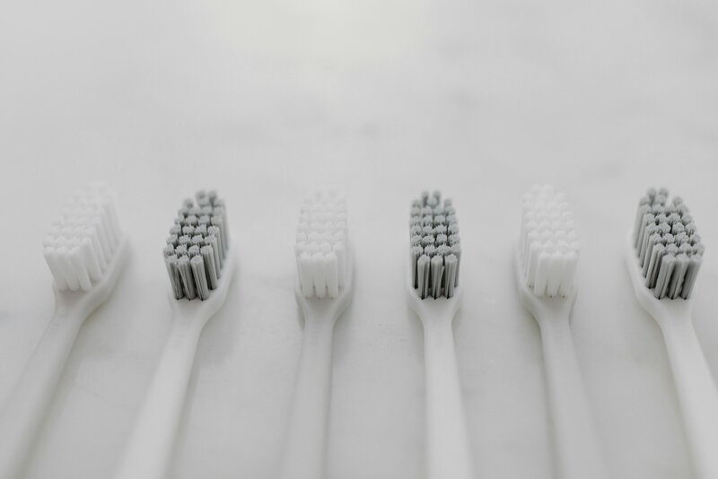 Detail bílých a šedých zubních kartáčků – symbol péče a hygieny