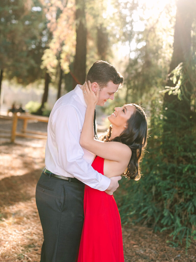 southern california engagement photo of couple wearing suit and tie and red dress at carbon canyon anaheim