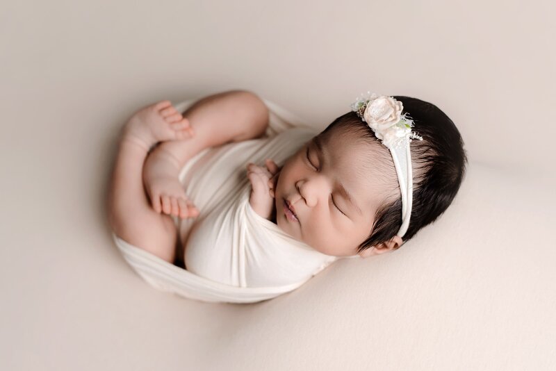 Vancouver newborn baby portrait session with newborn girl wrapped in cream