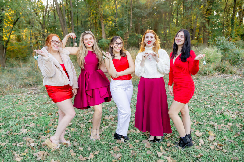 group of 6 college girls in pastel dresses with the beach at Klondike park behind them