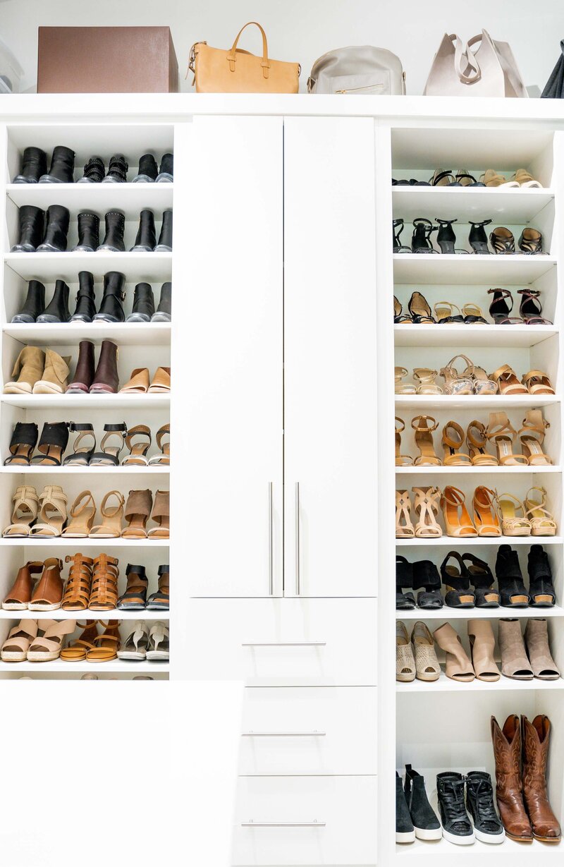 A primary closet featuring rows of organized shoes