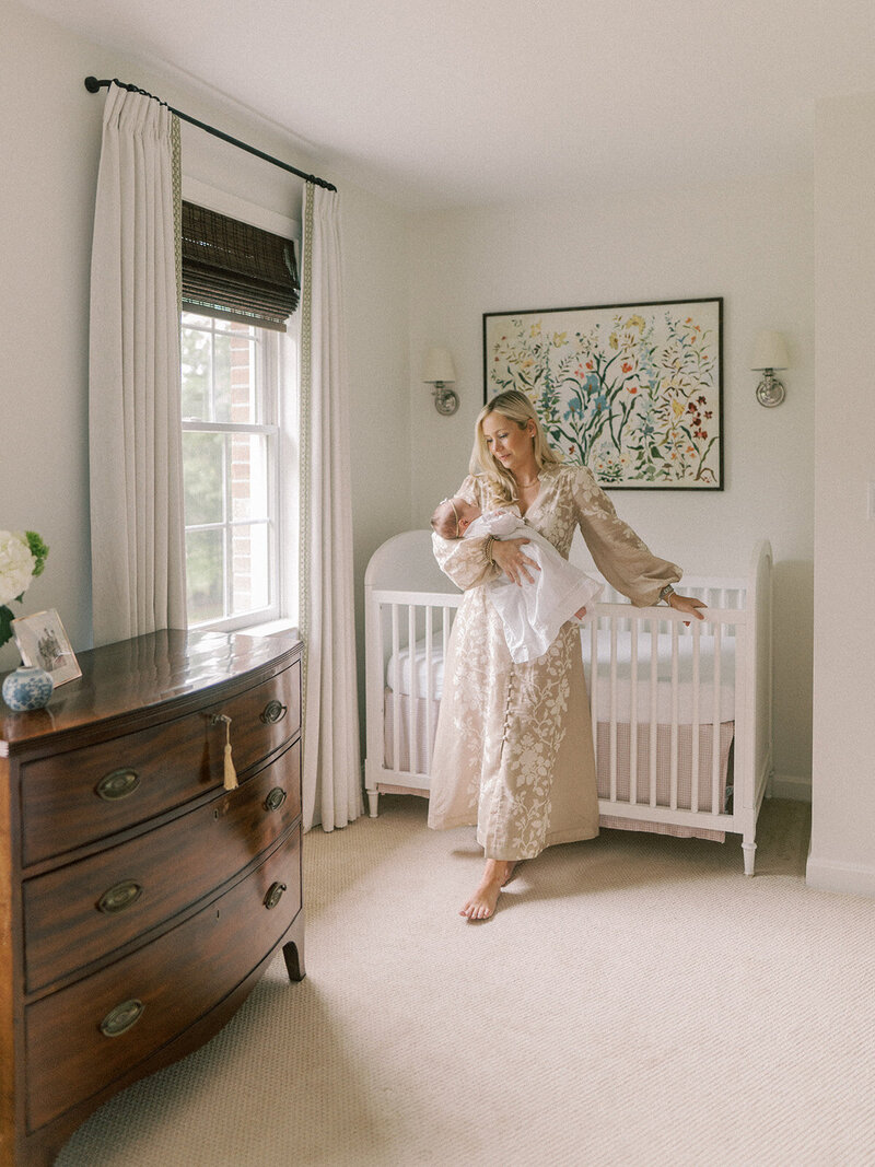 Mom holding her newborn baby in the nursery