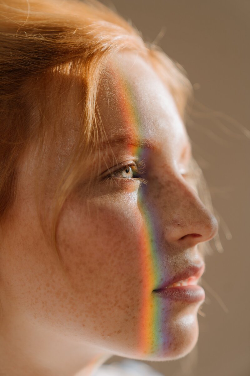 Woman with rainbow-colored hair and face
