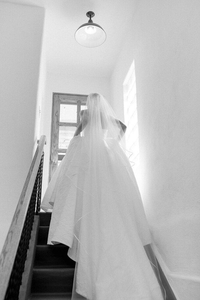 a bride walking up steps in her wedding dress and veil