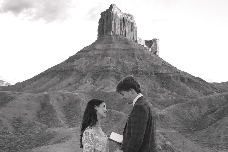 Couple exchanging vows with stunning views of the desert in Utah, while gazing into each other's eyes