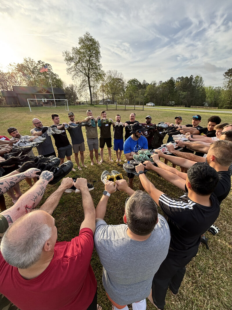 Joe Baker Fitness coach and young child participating in a custom group ruck training event in Statesville, NC with American flag in background | The Bakery Ruck Training.