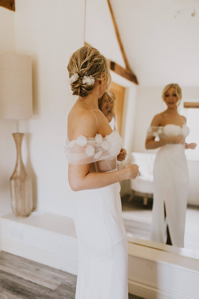 Bride looking into the mirror while getting ready in the Caswell House dressing room