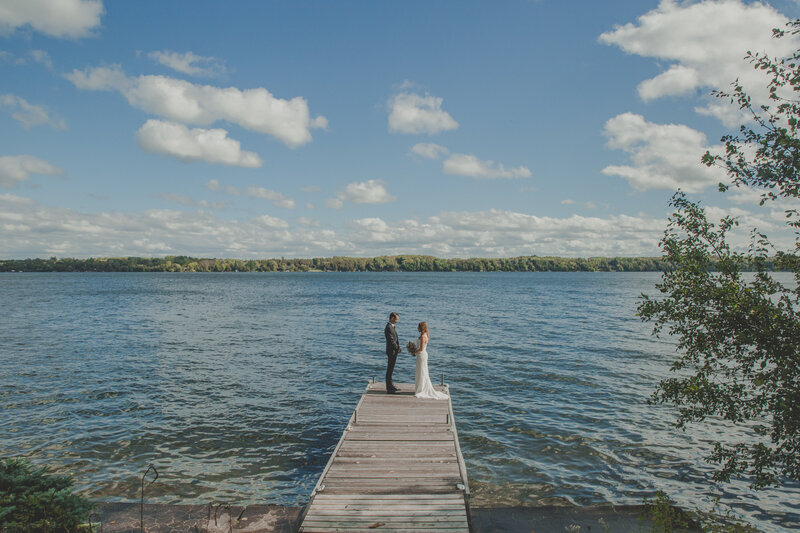 Couple getting married on dock by lake