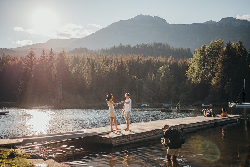 bride and groom twirl by the ocean during sunset