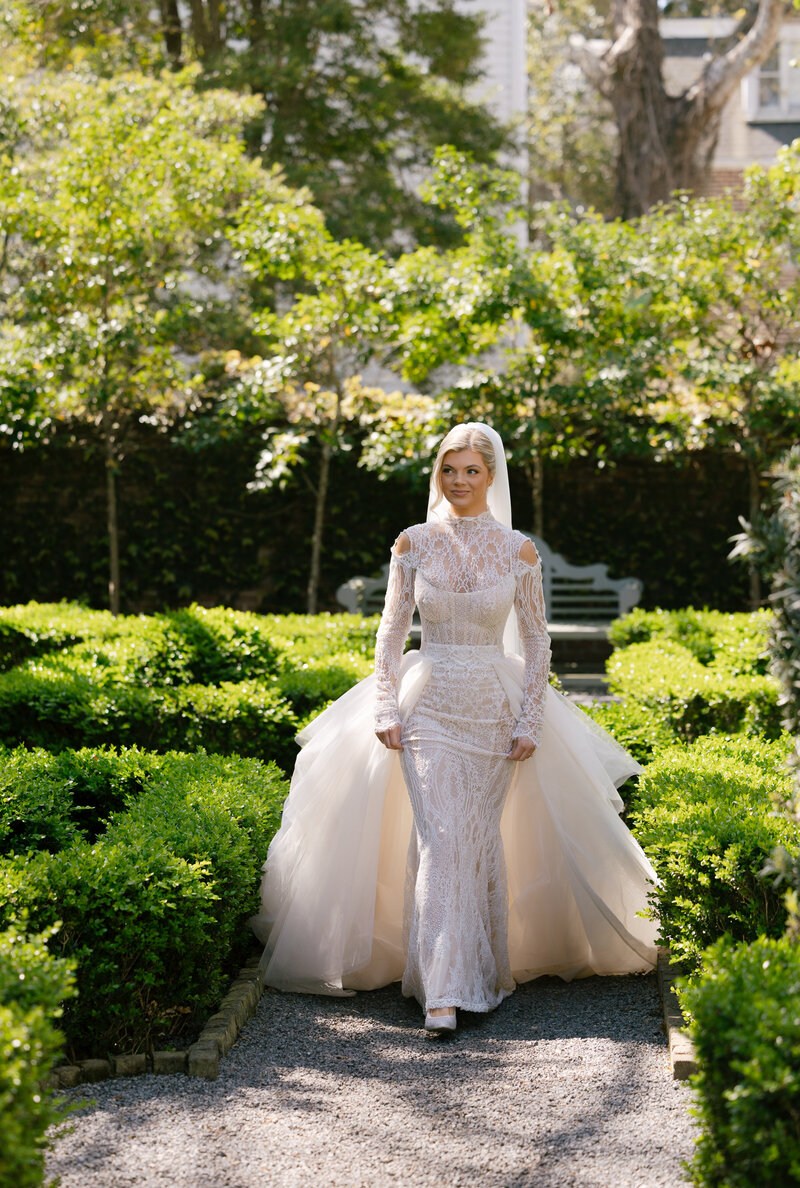 Bride posing gracefully in front of a Charleston historic home.