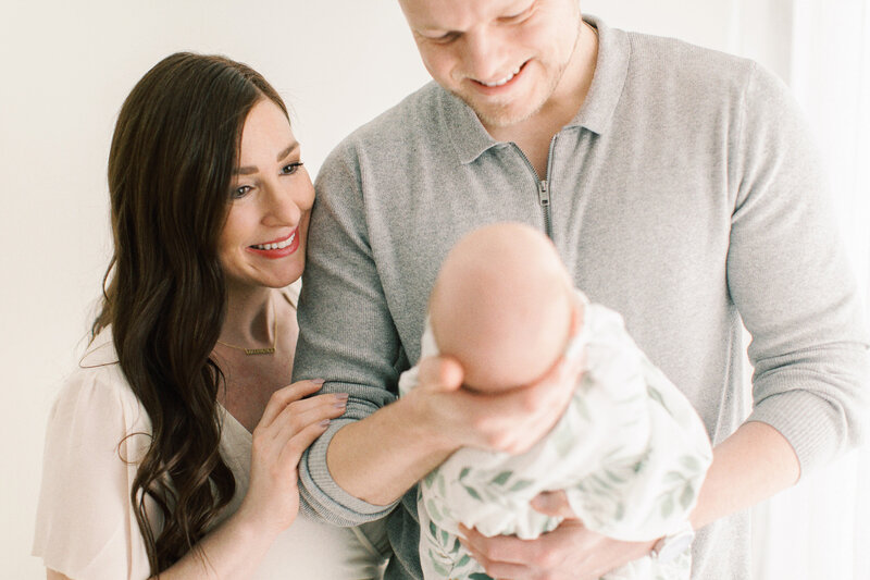 mom and dad smiling at baby by Chicago Newborn Photographer