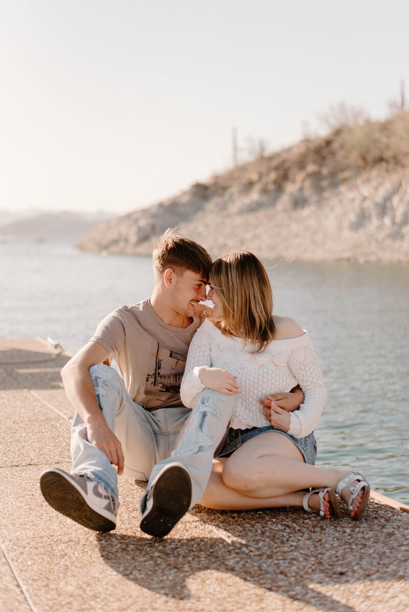 Lake pleasant marina couple session with couple sitting close to each other on a dock