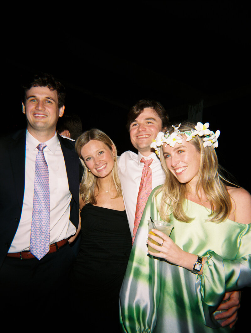 Flash film photo of wedding guests with their arms around each other