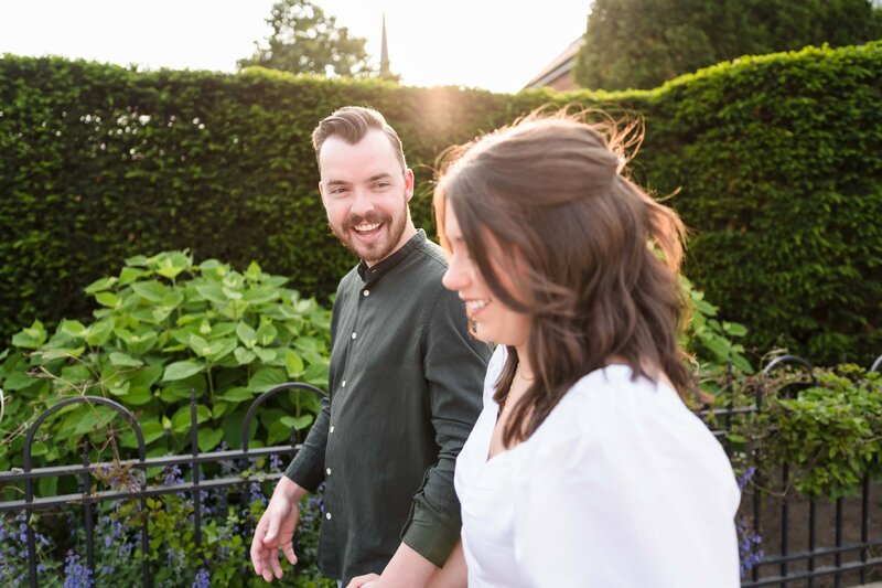 A young man smiles at his fiance as they walk the streets of German Village