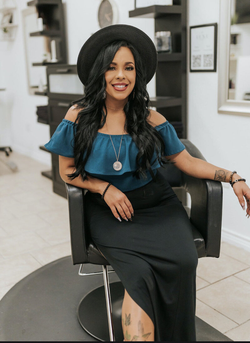 Idelisse smiling and sitting in salon chair