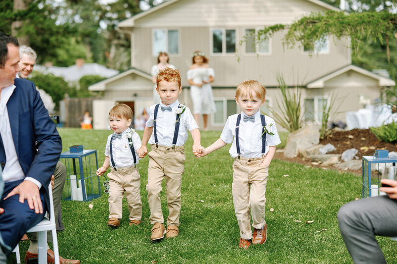 Ring bearers walk up the aisle holding hands