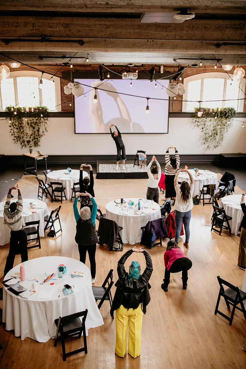 Michaela Ayers leads workshop participants through an immersive exercise before the workshop begins.